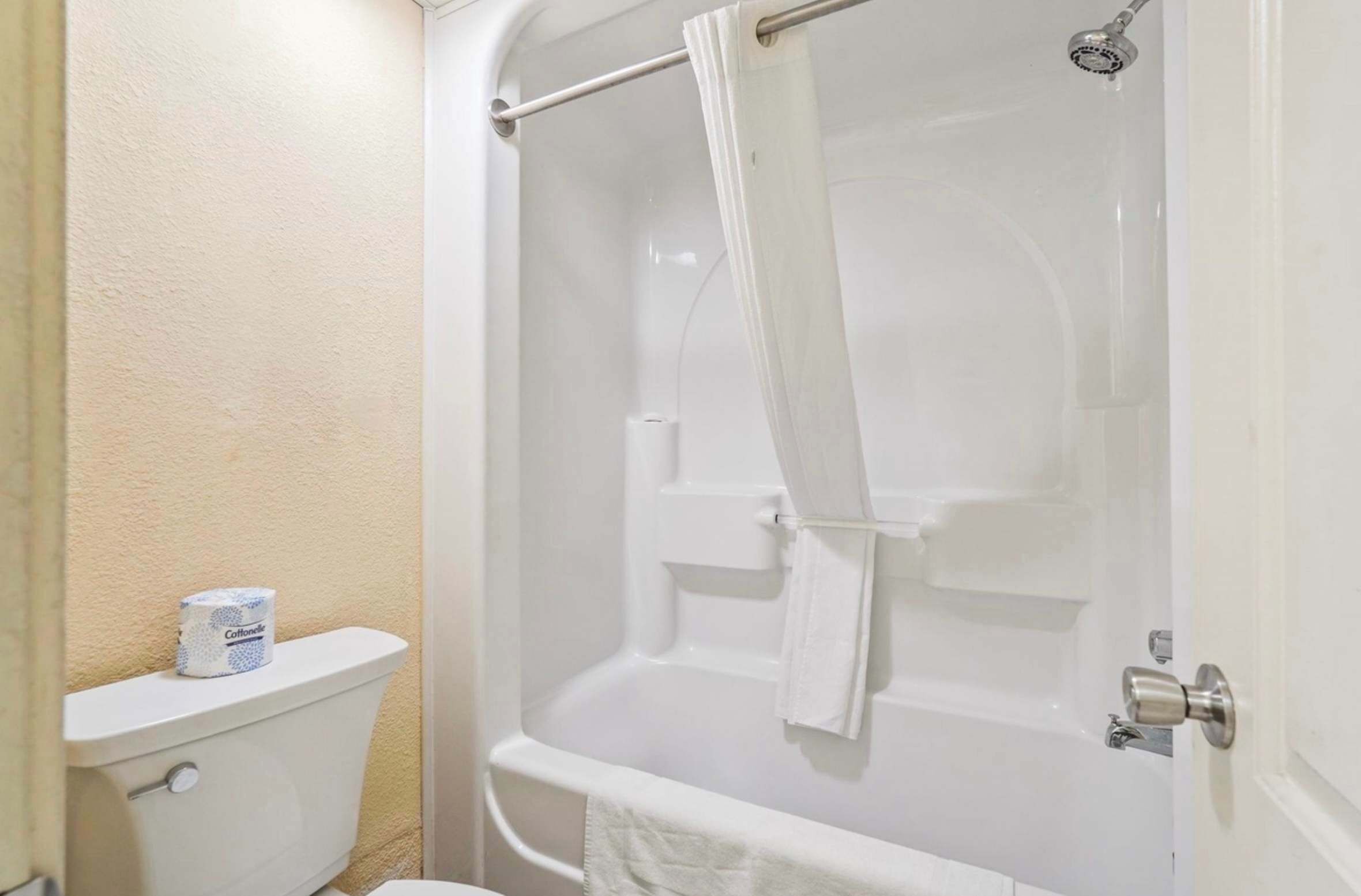 Ein Badezimmer mit Toilette, einer Dusche mit Glastür und einem Handtuchhalter.