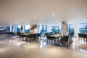A spacious restaurant with high ceilings, large windows, and modern decor. - Radisson Hotel Bareilly Airport (Bareilly)