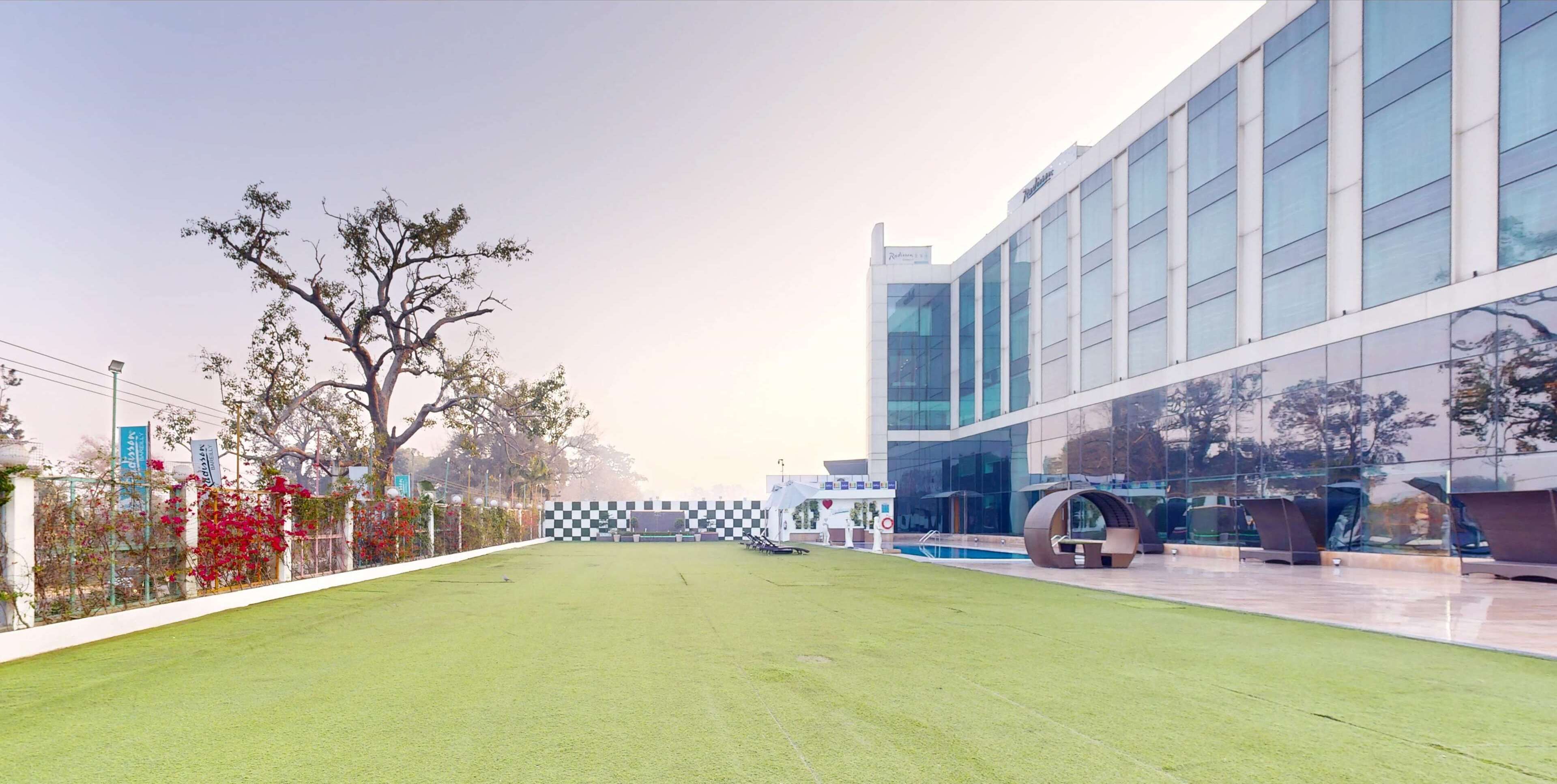 A modern building with a glass facade and a well-maintained lawn in front.