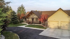 A two-story house with a stone facade, a front porch, and a garage.