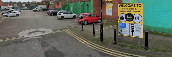 A parking area with a sign indicating it's a bank and car park.