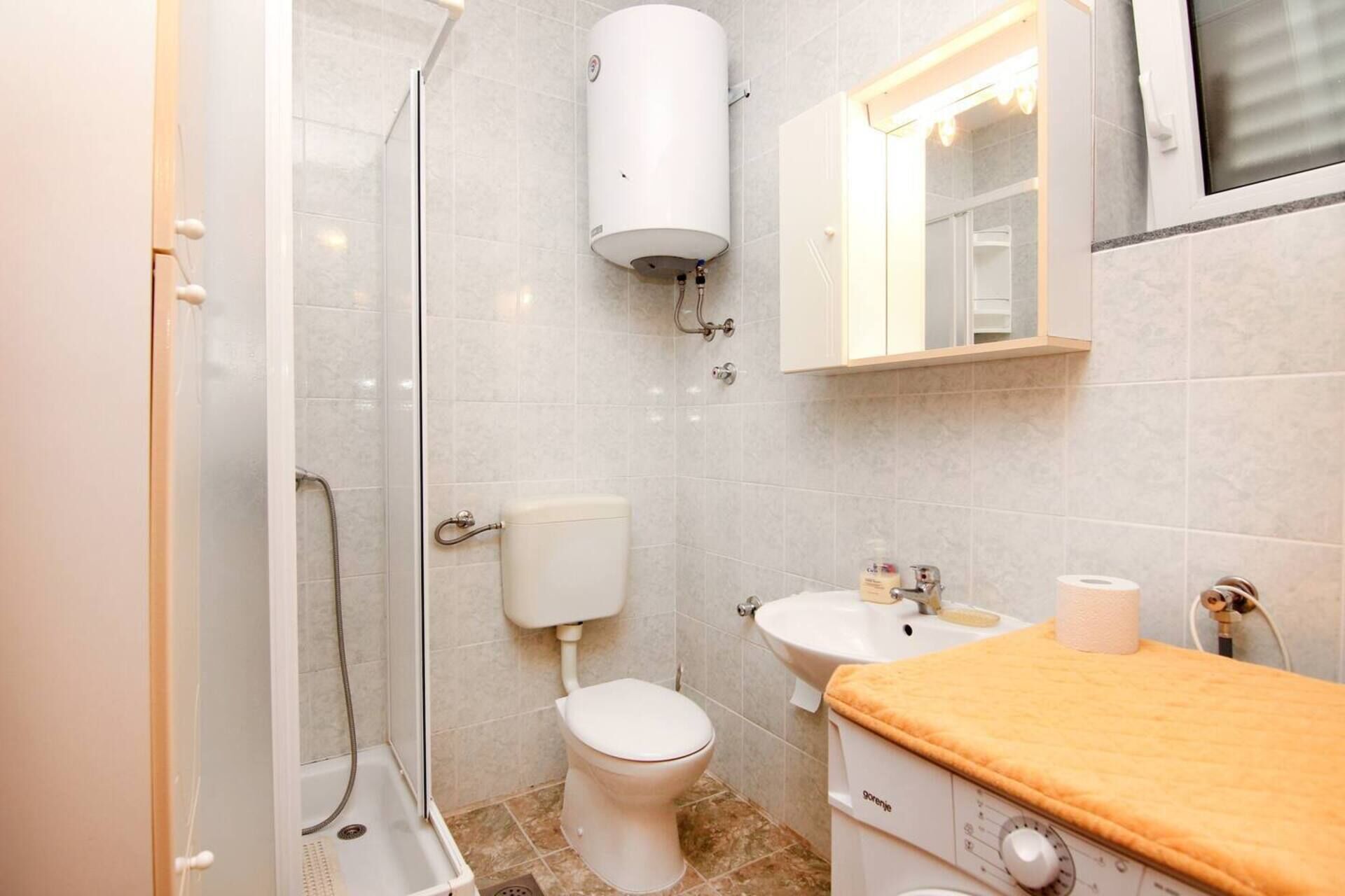 Une salle de bain équipée d’une douche, de toilettes, d’un lavabo et d’un porte-serviettes.