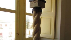 A twisted column sculpture in a room with a window and a door. - Arias la Suite del Duomo - Sea View Terrace (Cefalù)