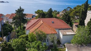 A coastal residential area with terracotta-tiled roofs, surrounded by greenery and overlooking the sea. - Art Apartment Nearby the sea (Dubrovnik)