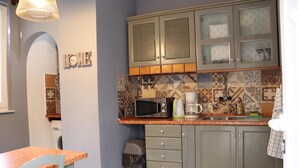 A kitchen with a microwave, coffee maker, and cabinets. - Art Apartment Nearby the sea (Dubrovnik)