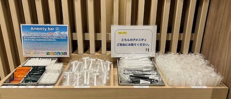 A hotel reception area with an 'Amenity bar' sign, a 'Smile Hotel' sign, and various items like toothbrushes and cups on display.