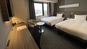 A hotel room with two beds, a desk, a chair, and a window with a city view. - Smile Hotel Shinosaka (Osaka)