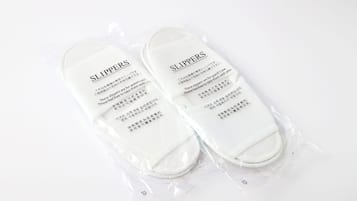 A pair of slippers in a plastic package with text on them.