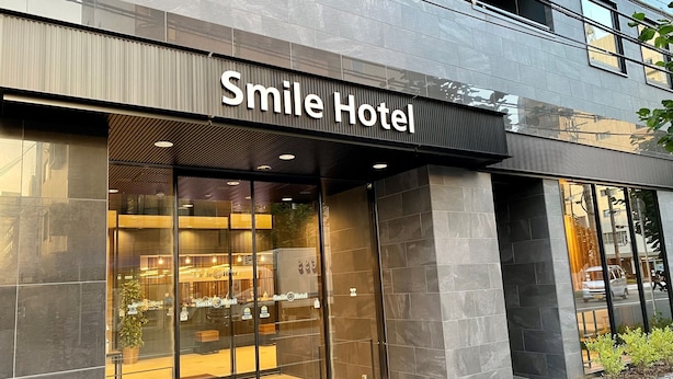 The exterior of Smile Hotel with a modern design, large glass windows, and a prominent sign above the entrance. - Smile Hotel Shinosaka (Osaka)