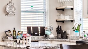 A kitchen with granite countertops, a coffee machine, and a window with blinds. - Entire House;  20 min to Beaches, Downtown Charleston, 6 min to Airport, Outlets (North Charleston)