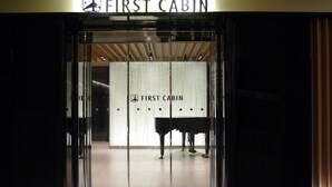 The entrance to First Cabin with a modern interior design, featuring a glass door and a sign above. - First Cabin Kansai Airport (Izumisano)