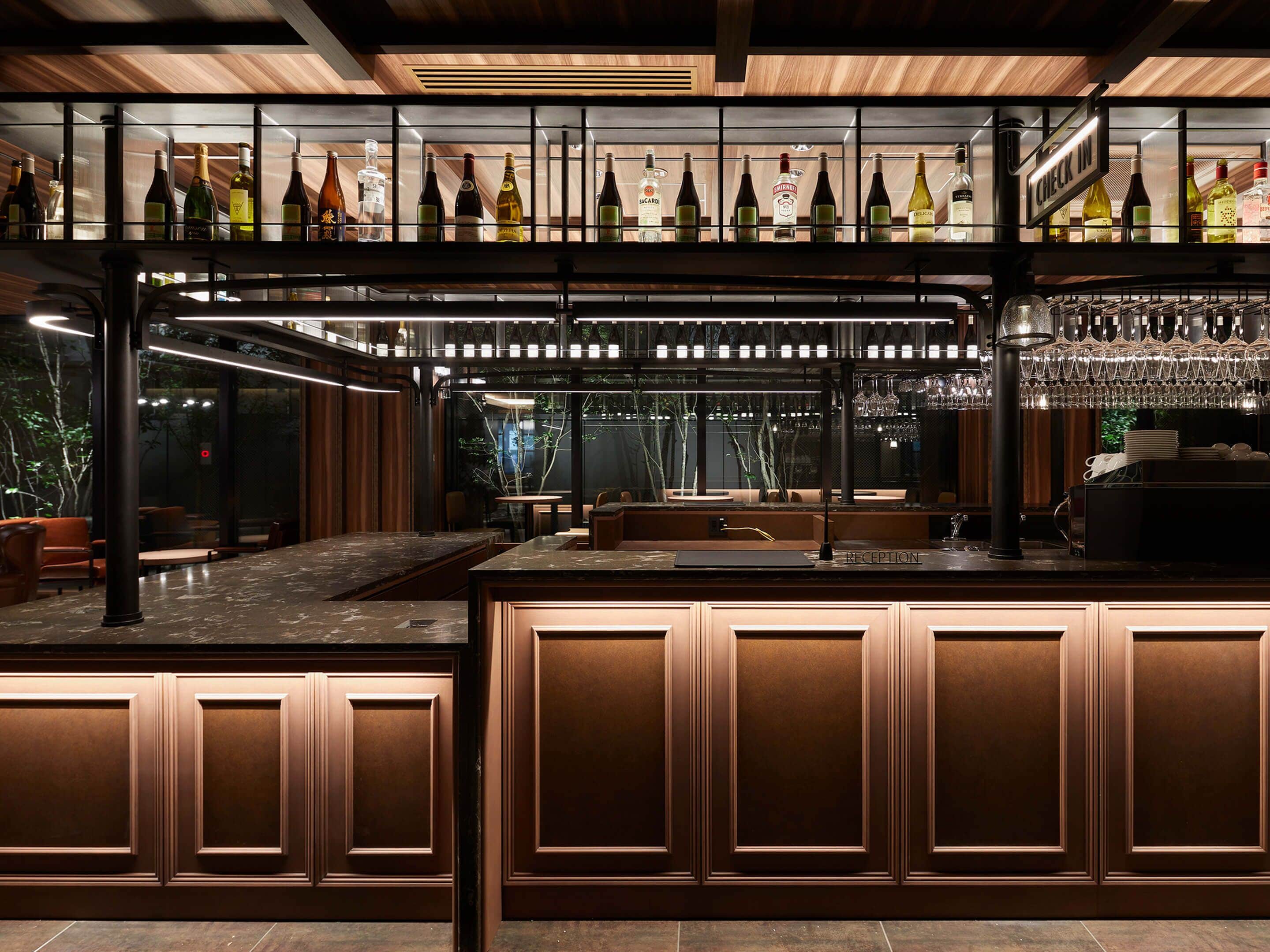 A bar area with a wine rack, seating, and a reception desk.
