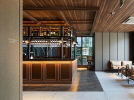 Zona de bar con techo de madera y mostrador de recepción.