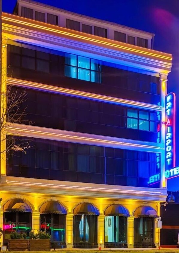 Ett hotell med flera våningar, utmärkt av en stor, lysande neonskylt med texten ”JET AIRPORT HOTEL”.