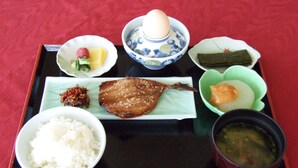 Un vassoio con diversi piatti della cucina giapponese, tra cui riso, pesce e zuppa.