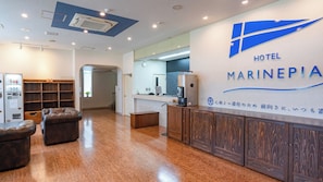 A hotel reception area with a modern design, including a reception desk, seating area, and a kitchenette. - Hotel Marinepia (Shinkamigoto)