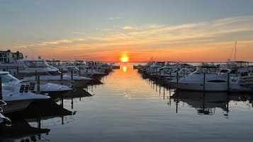 A marina with boats docked in calm waters during sunset.