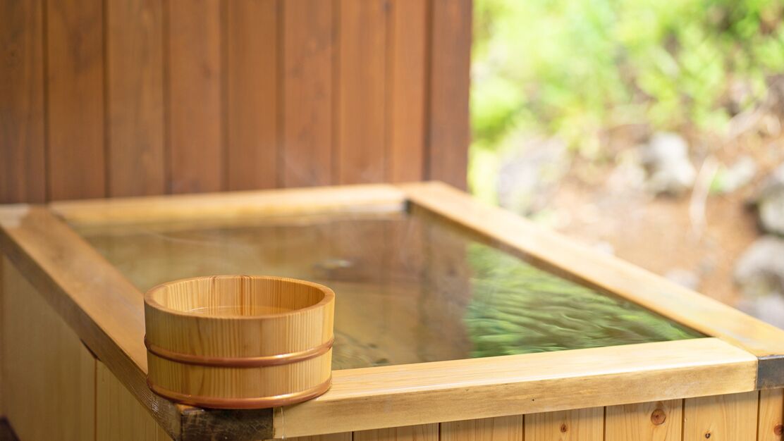 A wooden hot spring bath with a wooden bucket.
