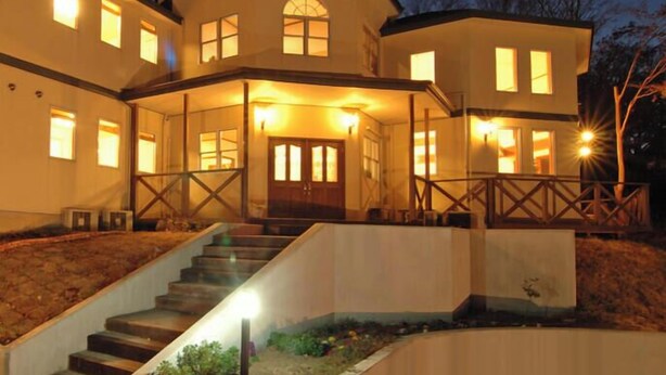 A multi-story house with a front porch, a staircase, and multiple windows. - Oyado Yurari (Ito)
