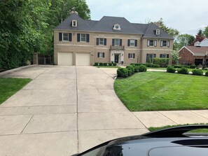 A two-story house with a garage, a driveway, and a well-maintained lawn.