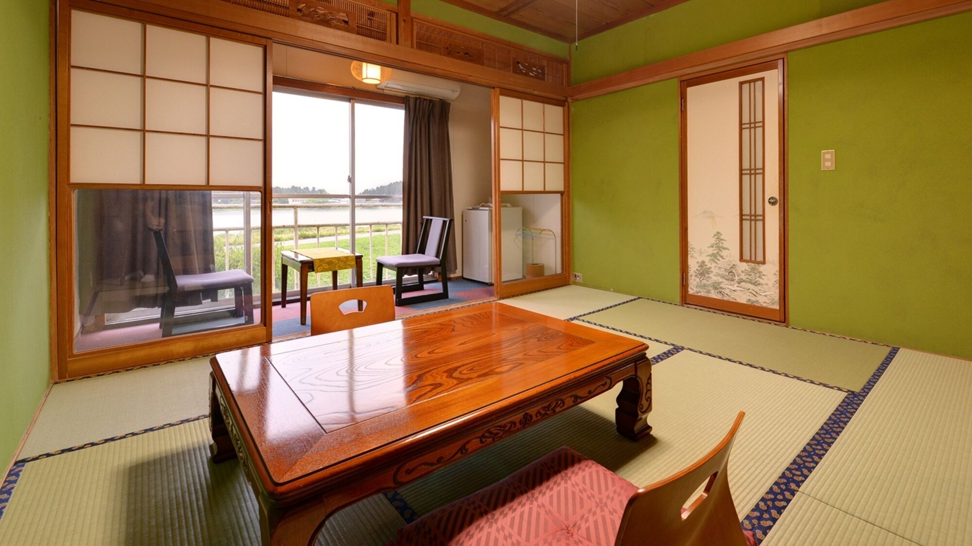Ein traditioneller japanischer Raum mit Tatami-Böden, einem Holztisch und Schiebetüren.