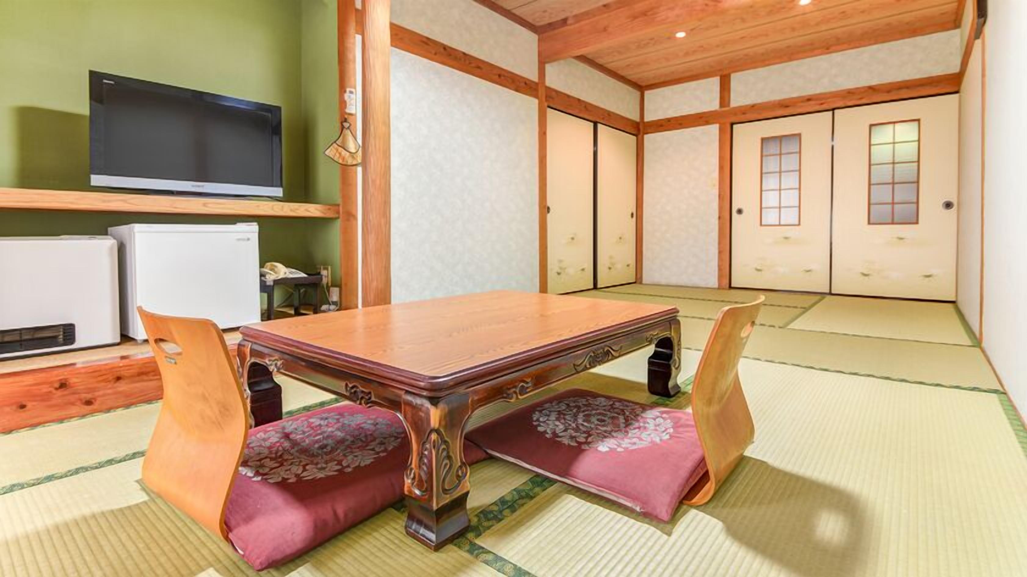 A traditional Japanese room with tatami flooring, a low wooden table, and a television on a shelf.