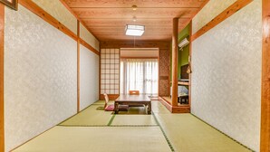 A traditional Japanese room with tatami flooring, a low table, and sliding doors. - Gyokusenkan (Ebino)