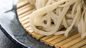 Un plato de espagueti con un borde de madera.