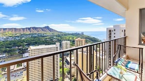 A balcony with a view of a cityscape, including buildings and a mountain range. - Waikiki Banyan condo w/ beach access & pool (Honolulu)