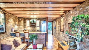A modern interior with a kitchen, dining area, and living space. - Seafront rental by Thierry Bourgait (Banyuls-sur-Mer)