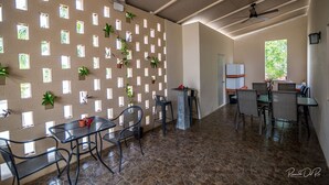 A spacious indoor area with a stone floor, a wall with small windows, and several tables and chairs. - AZCAPRI® Villa Boutique & Spa -Queen-  NEW! (Alfredo V. Bonfil)