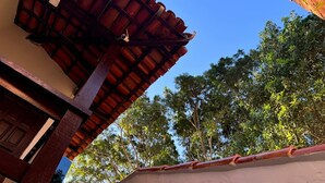 A building with a red-tiled roof and a concrete wall. - Suíte em Geribá, Próximo a Praia (Armação do Búzios)