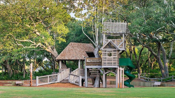 A treehouse structure with a wooden staircase and a sign that reads "The Treehouse."