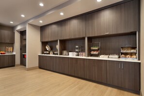 Modern kitchen with dark cabinetry, light countertops, and ample storage.
