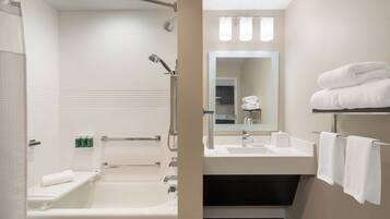 Une salle de bain moderne équipée d’une baignoire, d’une douche, d’un lavabo et d’un miroir.