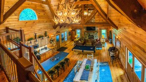 A spacious log cabin with a dining area, kitchen, and living room.