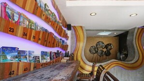 A reception area with a wooden counter, numbered lockers, and a decorative wall with circular patterns. - Baan Kamala Fantasea Hotel (Kamala)