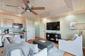 A spacious living area with a kitchen, a ceiling fan, a flat-screen TV, and a comfortable seating arrangement. - 1BR/1BA in Inlet Beach with amazing view! (Panama City Beach)