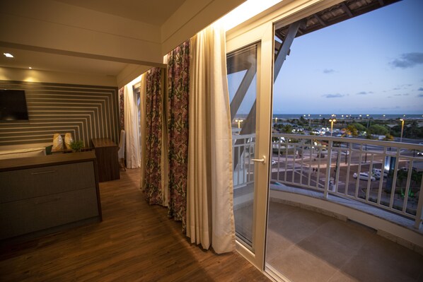 A balcony with a view of a cityscape at dusk.