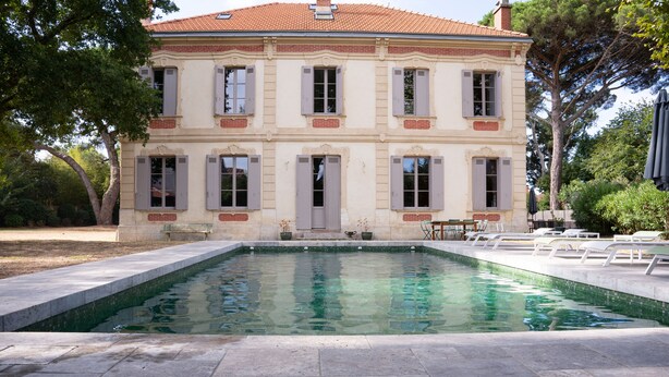 Un edificio de dos pisos con piscina delantera.