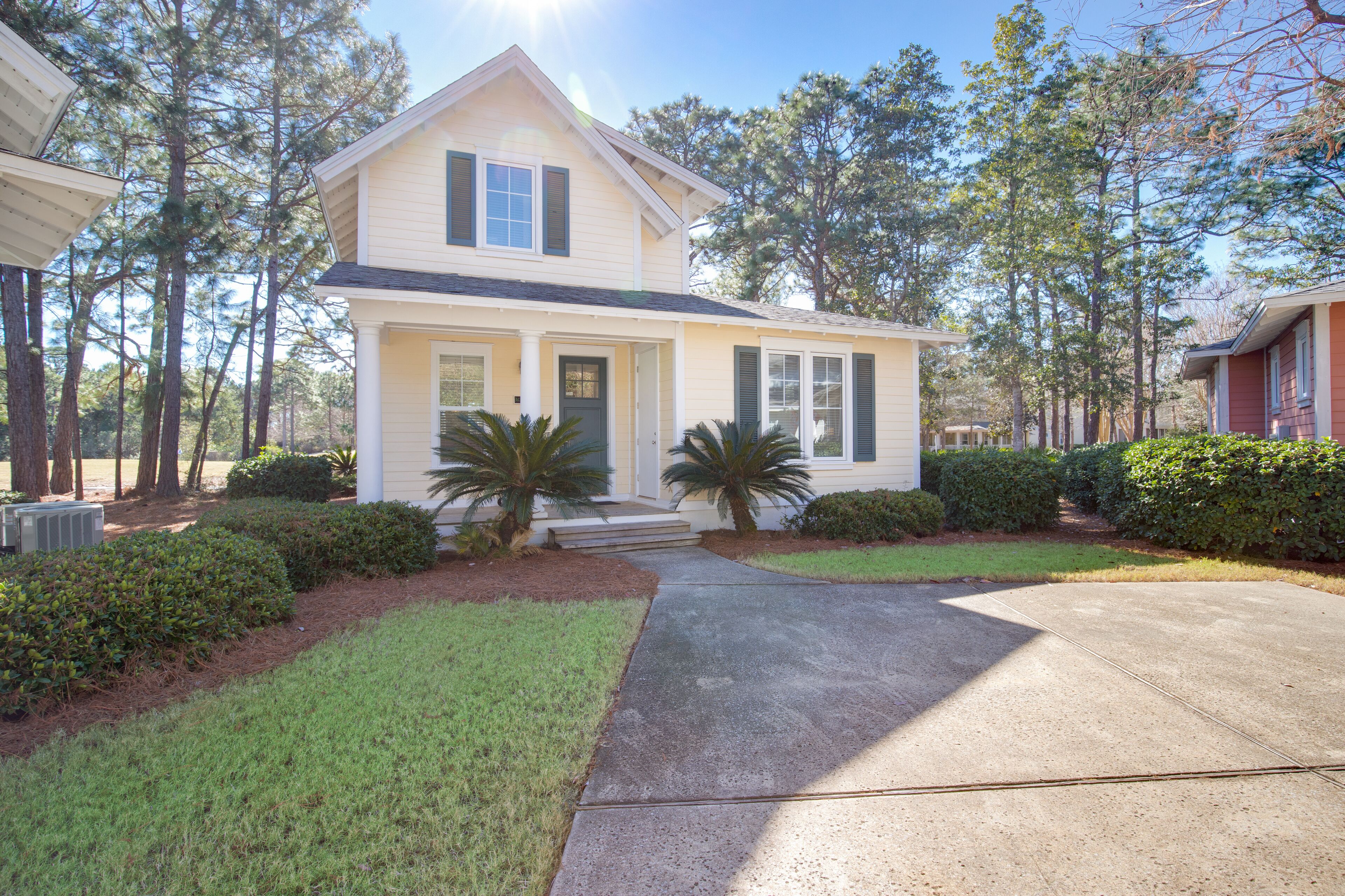 A two-story house with a front porch, a driveway, and a well-maintained lawn.