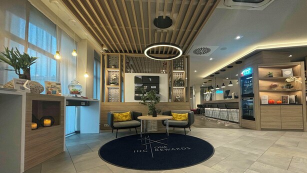 Un interior moderno con una recepción, zona de estar y un bar.
