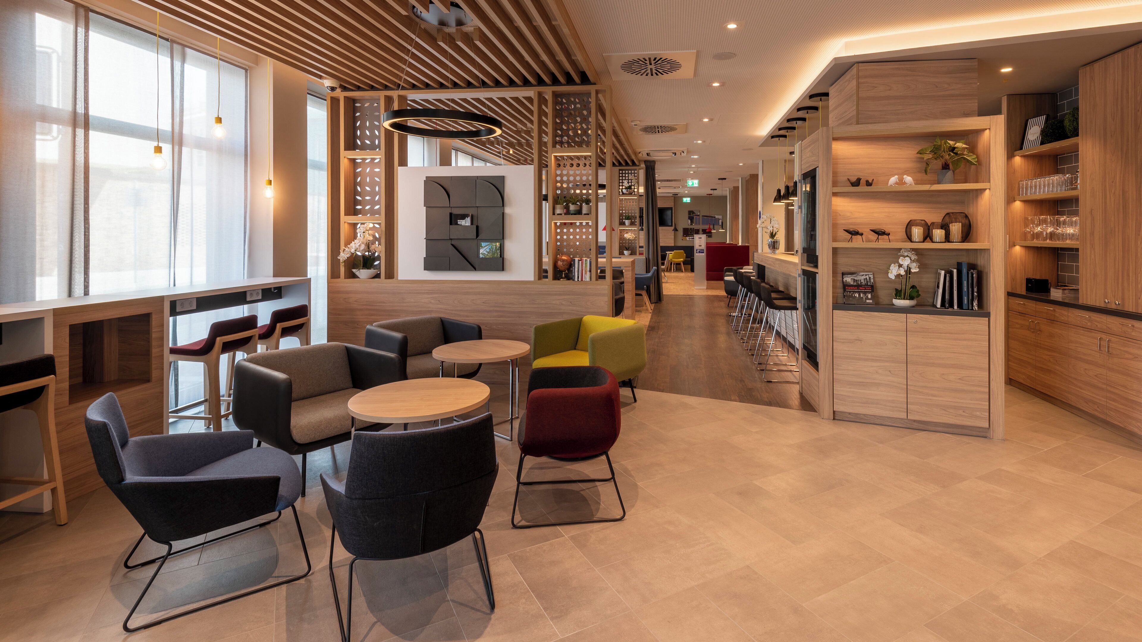 A modern interior with seating areas, a bar, and a reception desk.