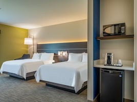 Habitación de hotel con dos camas, microondas, cafetera y refrigerador.