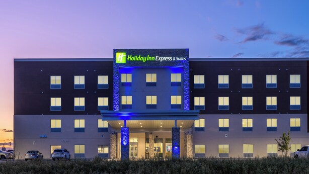 A Holiday Inn Express & Suites building with a modern facade, multiple windows, and a well-lit entrance. - Holiday Inn Express & Suites Watertown by IHG (Watertown)