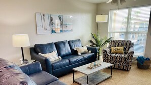 A modern living room with a sectional sofa, a patterned armchair, and a coffee table.