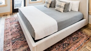 Un dormitorio con cama, ventilador de techo, ventana y puerta.