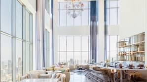 A spacious hotel lobby with large windows, a chandelier, and a bar area. - SLS Dubai Hotel & Residences (Dubai)