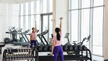 Een sportschool met fitnessapparatuur, waaronder loopbanden en gewichten.