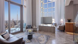 A spacious living room with a large window offering a city view, a modern chandelier, and a flat-screen TV. - SLS Dubai Hotel & Residences (Dubai)